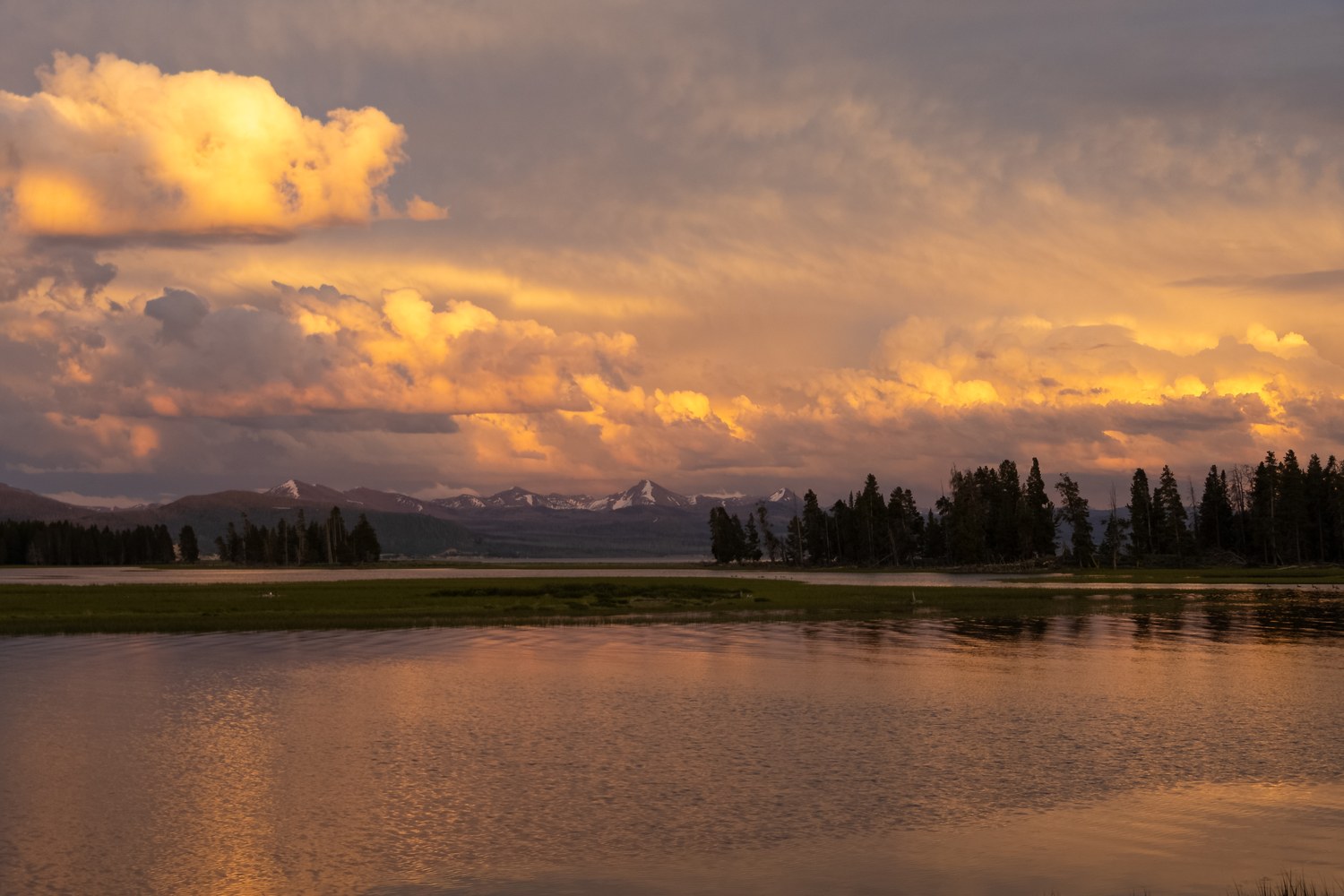 Sunset clouds glowing over Pelican Creek with the Absaroka Range along the horizon.